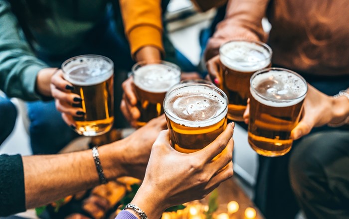 A number of hands holding pints of beer