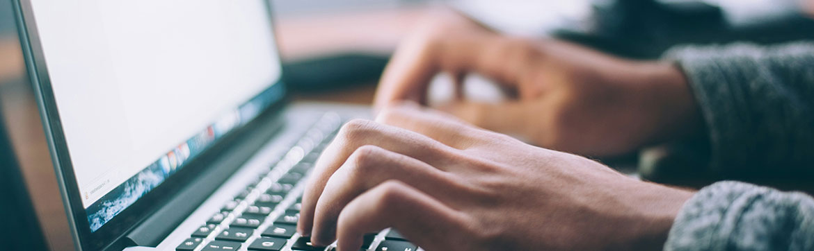 A person typing on a computer keyboard