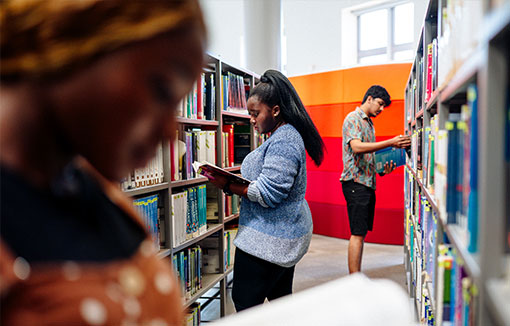 Several students finding books in the Swansea University library