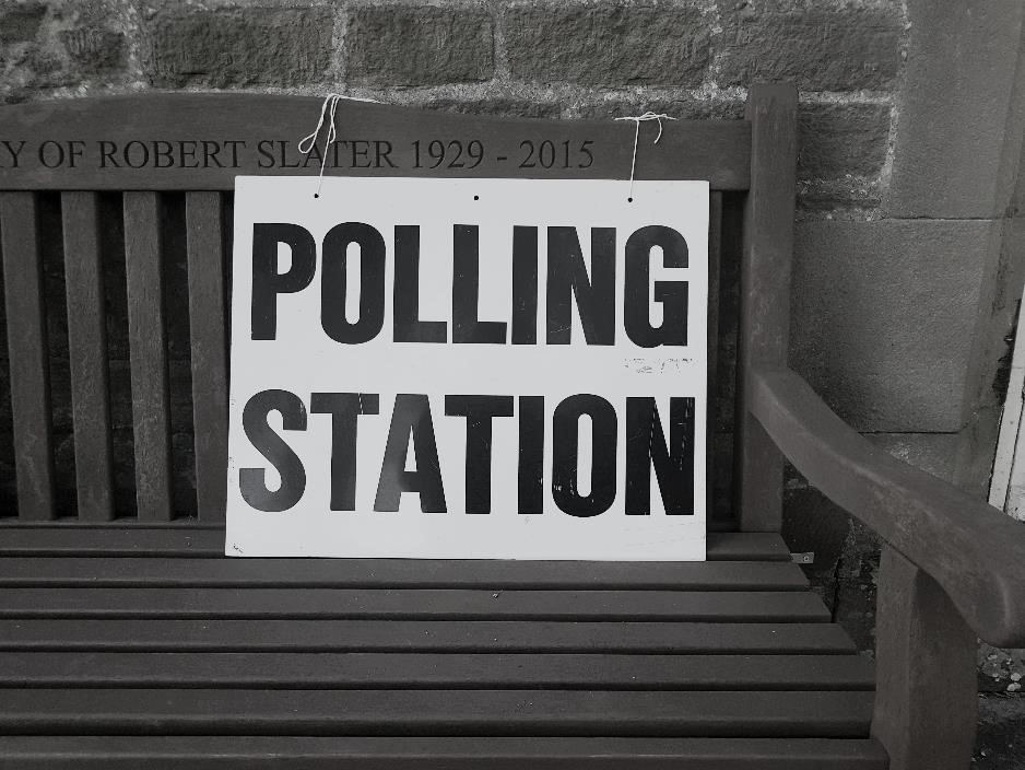 'Polling Station' card on a wooden bench. 