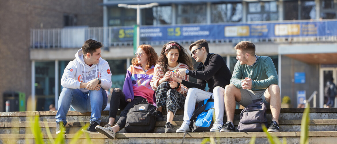 Students sitting outside Fulton House in the sunshine