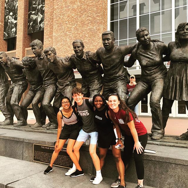 Student and friends in front of statue