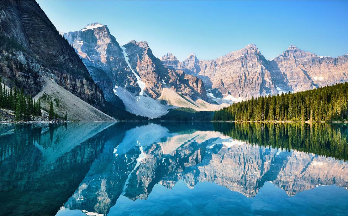 Canadian mountains being reflecting off a lake