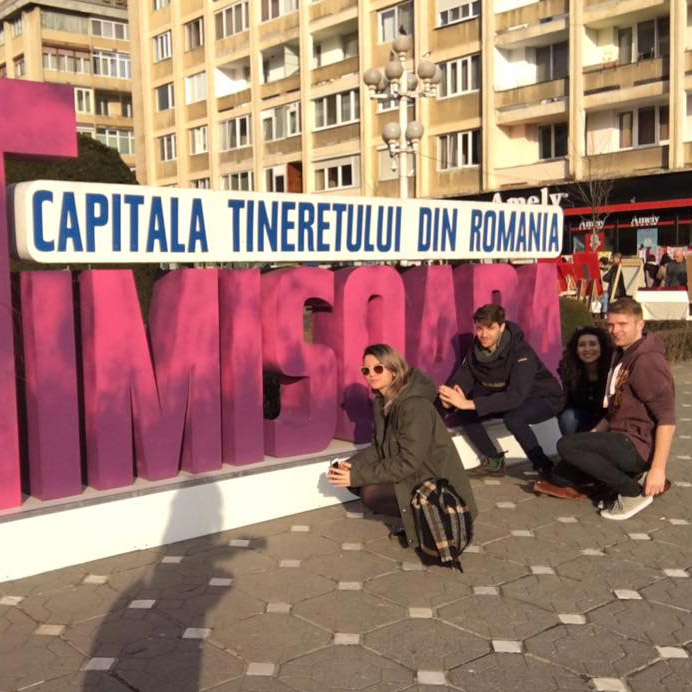 Ed and a group of friends with a sign in Romania