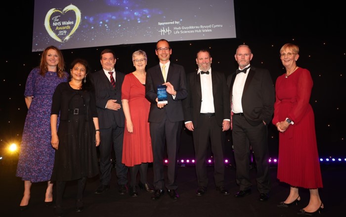 A group photo of the PROSTAD team on stage as they accept the award for NHS Wales Efficient Care.