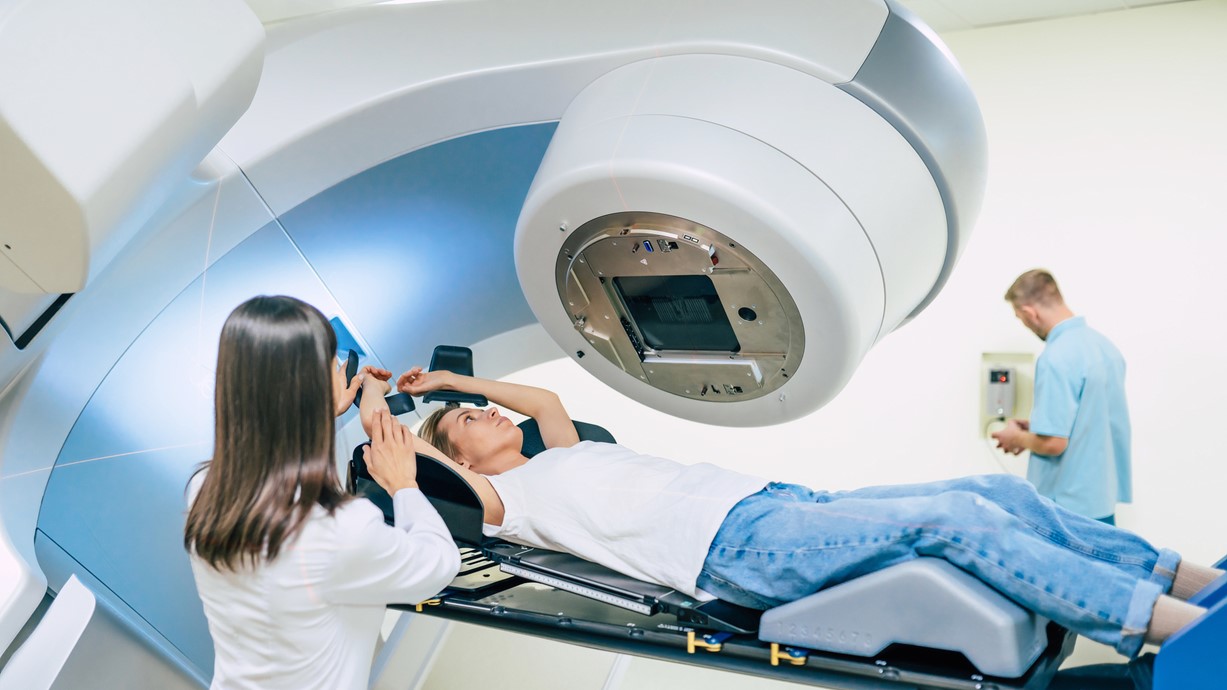 A stock photo of a woman undergoing radiation therapy using a linear accelerator.