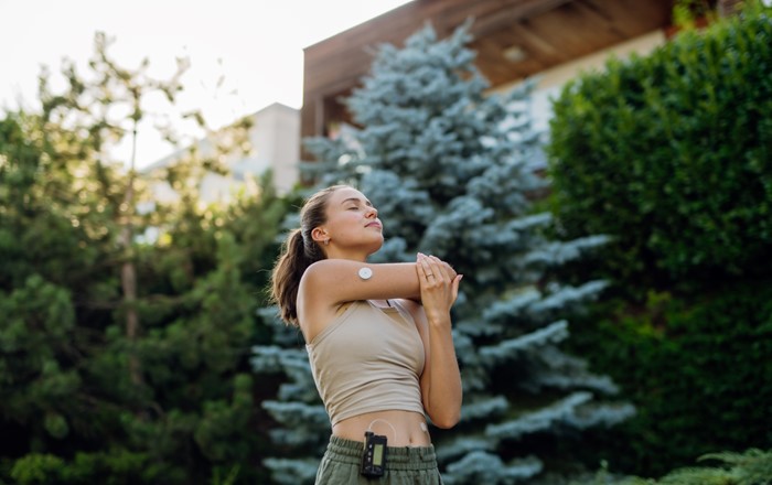 A photo of a woman using an AID system stretching before she exercises. Credit: Halfpoint