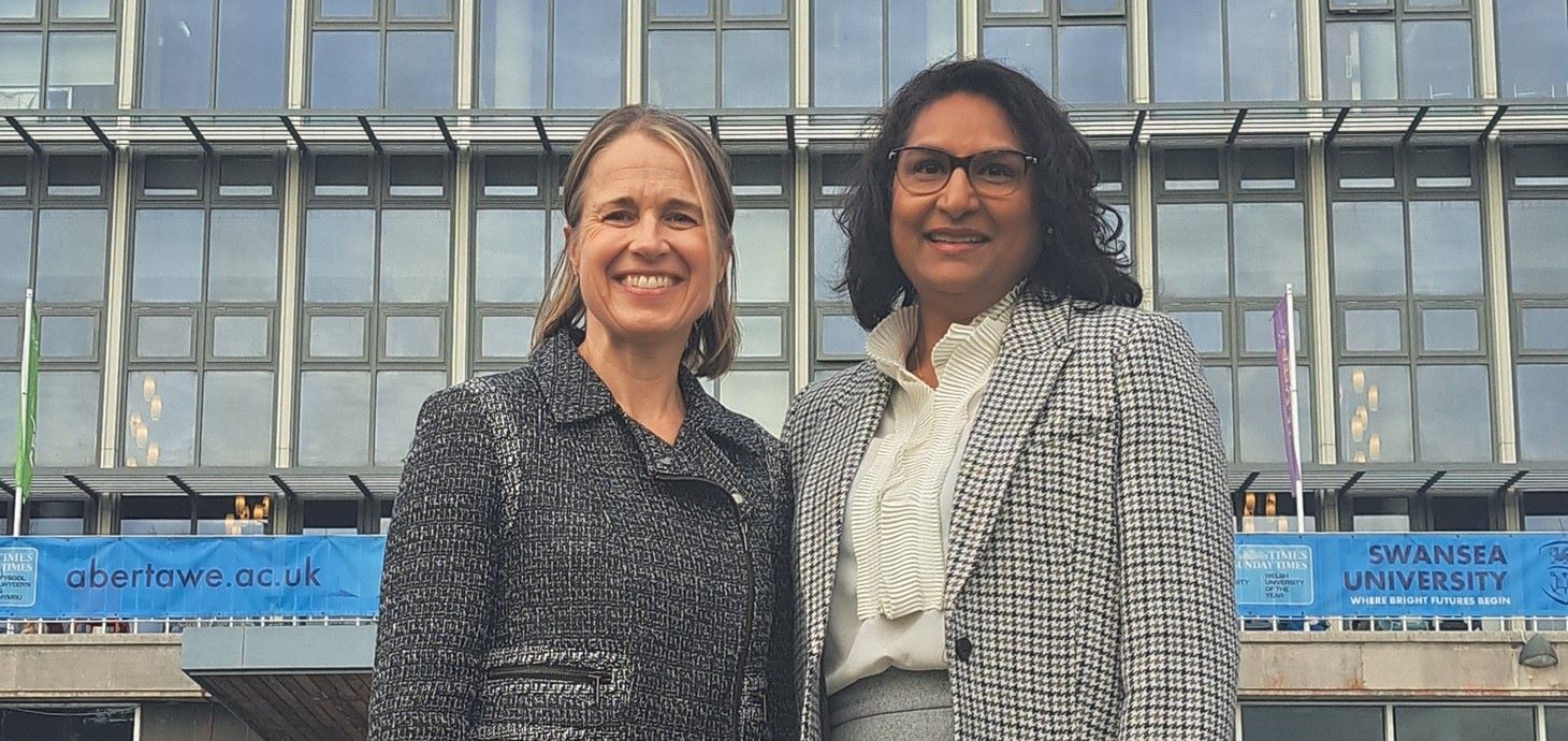 Two women standing in front of a building.