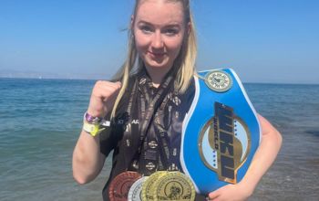 Sports Scholar, Charley Davies, holding the winning belt and medals 