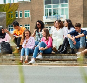 A group of students sitting on the steps of Fulton lawn, Singleton Campus