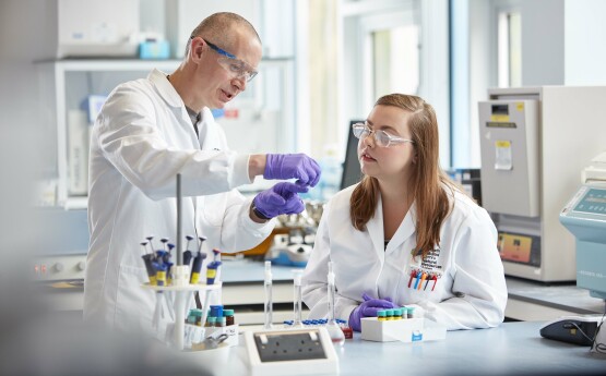 Student and academic working in a science lab