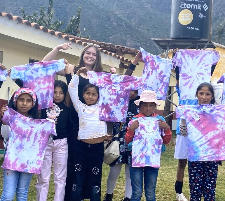 Student with children showing off their tie-dye.