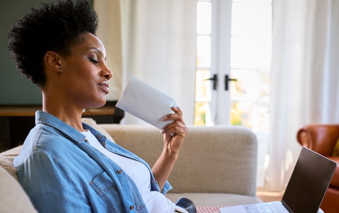 A woman sat on a sofa fanning herself